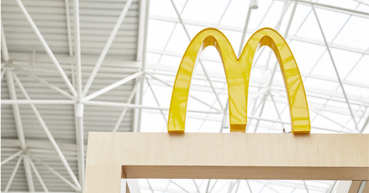 McDonald's Golden Arches on top of a wooden frame outside of a restaurant
